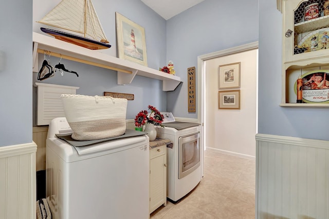 clothes washing area with washing machine and dryer and light tile patterned floors