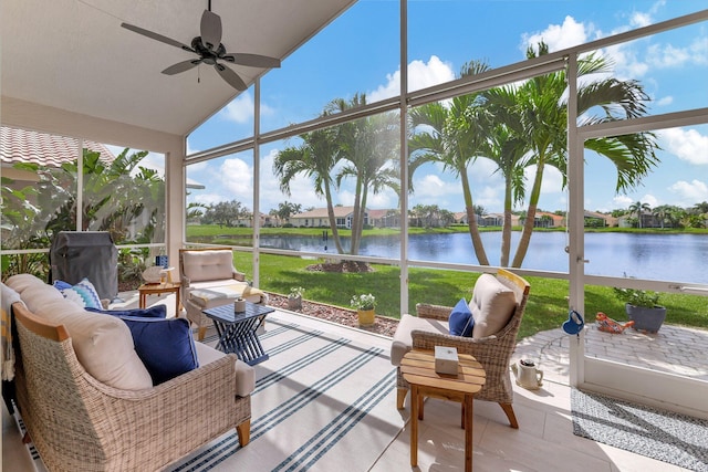 sunroom / solarium featuring lofted ceiling, a water view, and ceiling fan