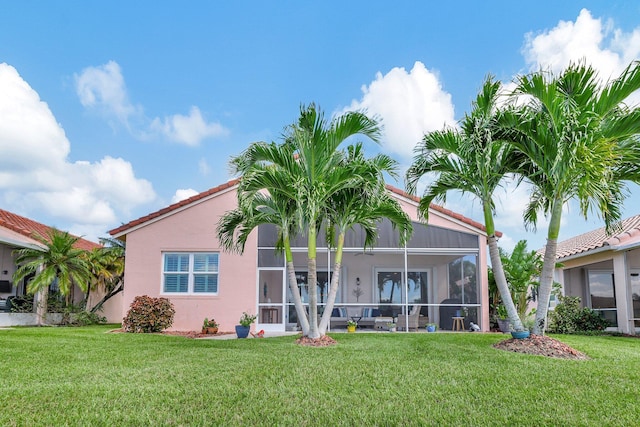 back of house with a sunroom and a lawn