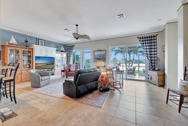 living room with crown molding, ceiling fan, light tile patterned floors, and a wealth of natural light