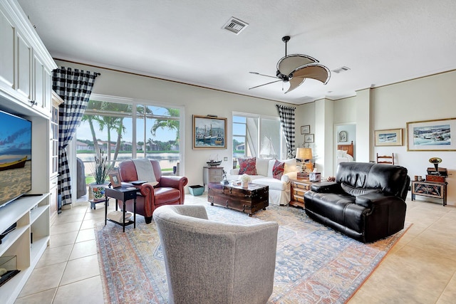 living room with ornamental molding, ceiling fan, and light tile patterned floors