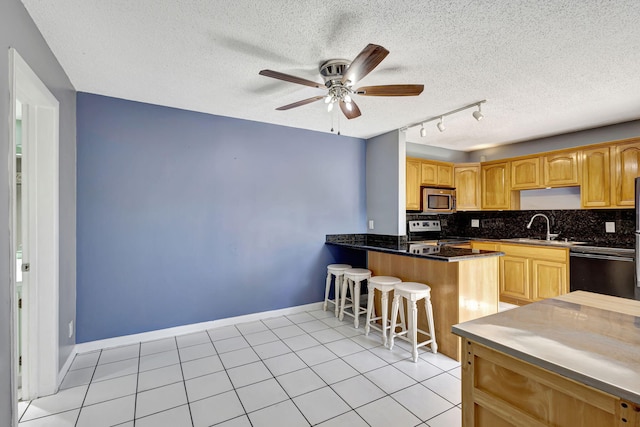 kitchen with stainless steel appliances, kitchen peninsula, light tile patterned floors, ceiling fan, and backsplash