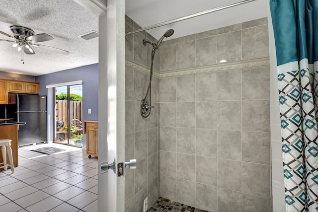 bathroom with ceiling fan, a textured ceiling, and walk in shower