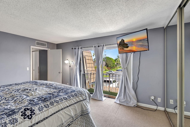 bedroom featuring a textured ceiling, access to outside, and carpet