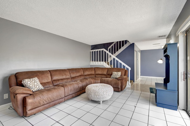 living room with a textured ceiling and light tile patterned flooring