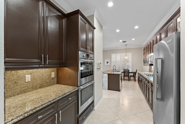 kitchen featuring appliances with stainless steel finishes, tasteful backsplash, ornamental molding, pendant lighting, and light tile patterned floors