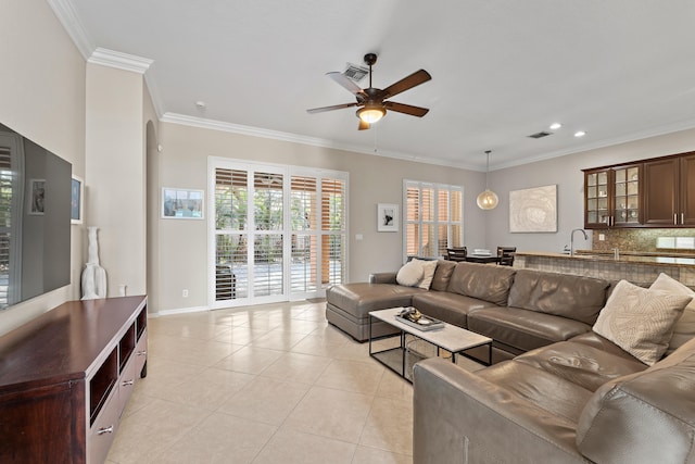 living room with ceiling fan, ornamental molding, sink, and light tile patterned floors