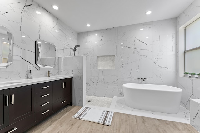 bathroom featuring vanity, wood-type flooring, tile walls, and plus walk in shower