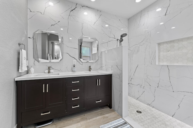 bathroom featuring hardwood / wood-style flooring, vanity, and a shower