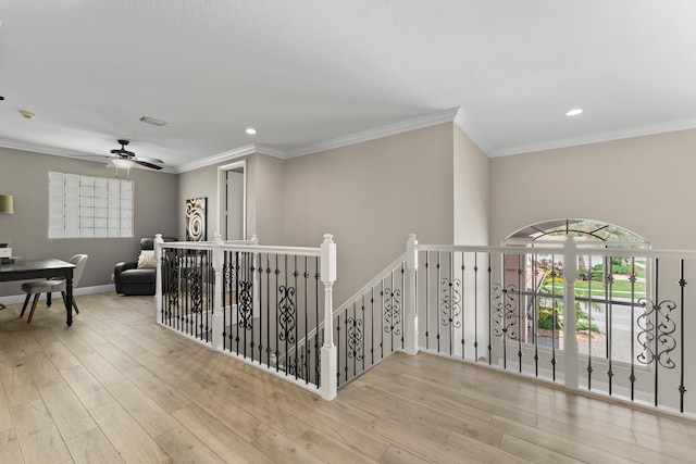 corridor with light wood-type flooring and crown molding