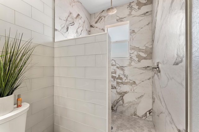 bathroom with toilet and a tile shower