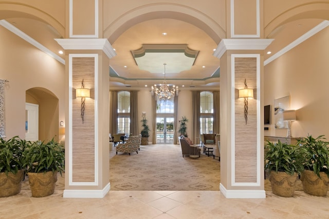 tiled foyer entrance with french doors, a towering ceiling, and ornamental molding