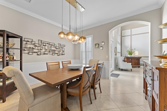 dining area featuring light tile patterned floors and crown molding