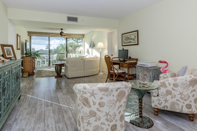 living room featuring light hardwood / wood-style flooring and ceiling fan