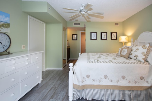 bedroom with ceiling fan, dark hardwood / wood-style flooring, and a textured ceiling