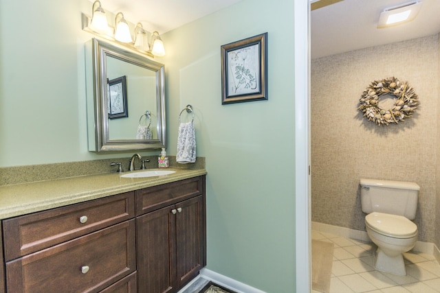 bathroom with tile patterned flooring, vanity, and toilet