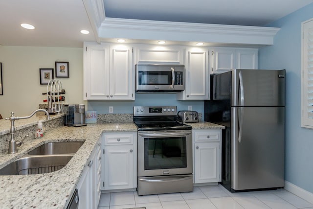 kitchen with white cabinetry, sink, stainless steel appliances, light stone counters, and light tile patterned floors