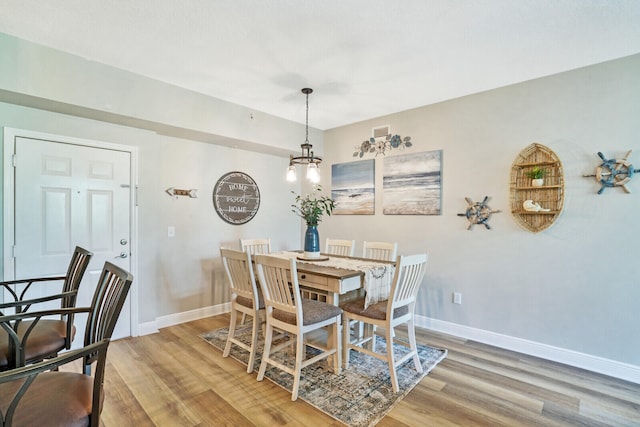 dining room featuring light hardwood / wood-style flooring and a notable chandelier