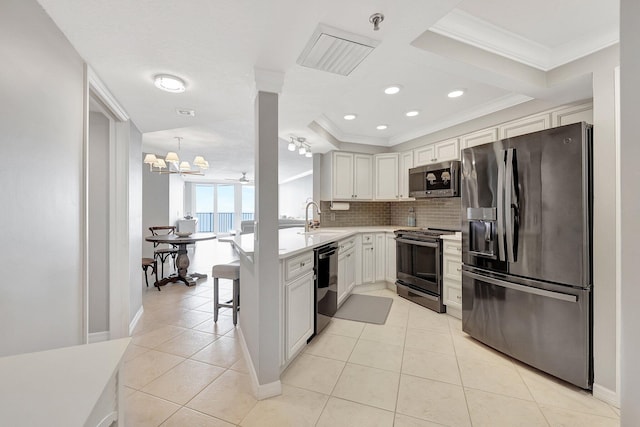 kitchen with backsplash, crown molding, white cabinets, and stainless steel appliances