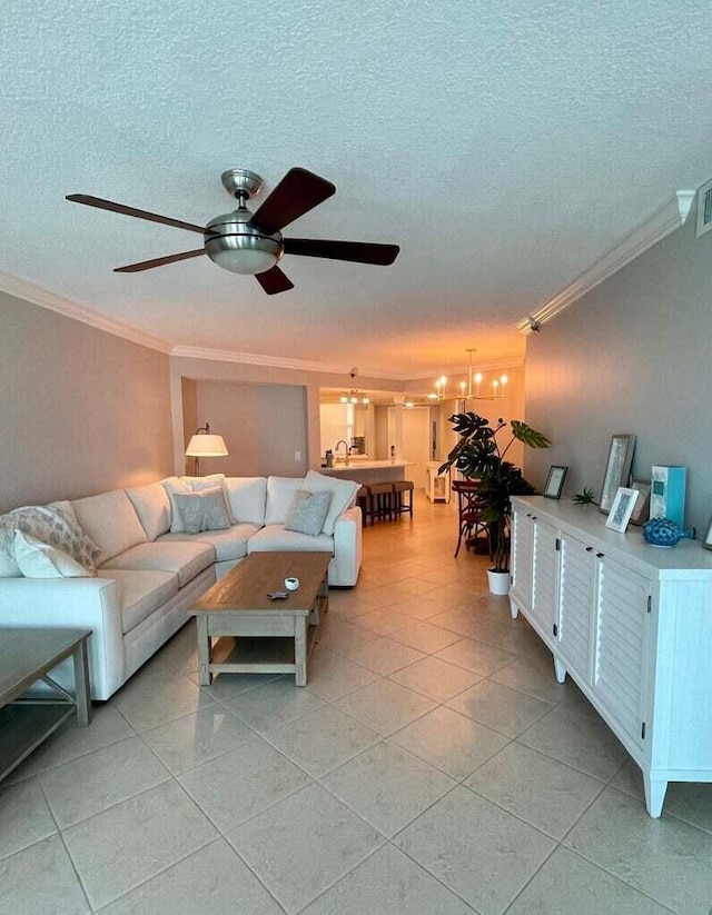 living room featuring ceiling fan with notable chandelier, a textured ceiling, and crown molding