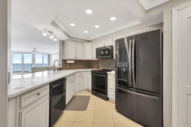 kitchen featuring decorative backsplash, sink, crown molding, and black appliances