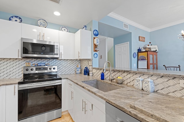 kitchen featuring backsplash, appliances with stainless steel finishes, sink, and white cabinetry