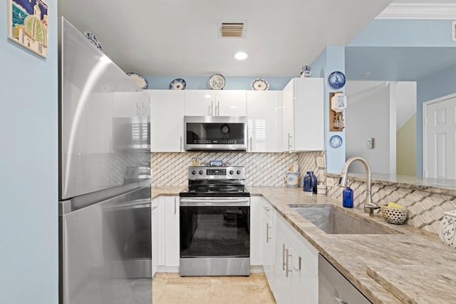 kitchen featuring light stone counters, white cabinets, sink, backsplash, and stainless steel appliances