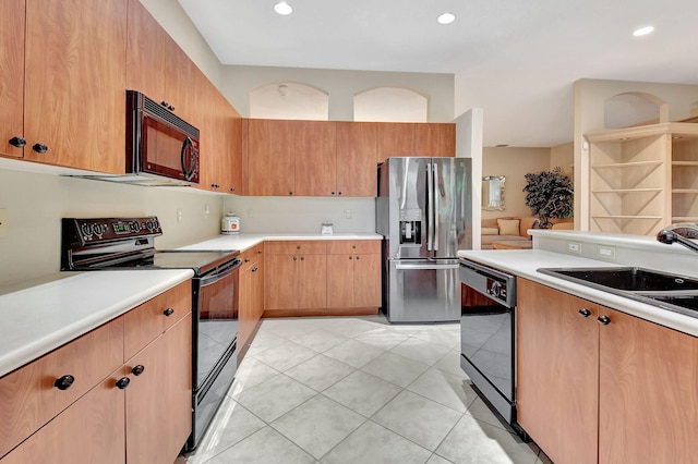 kitchen featuring black appliances, sink, and light tile patterned floors