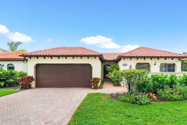 mediterranean / spanish-style house with a front yard and a garage