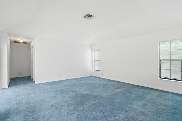 carpeted empty room featuring lofted ceiling and plenty of natural light