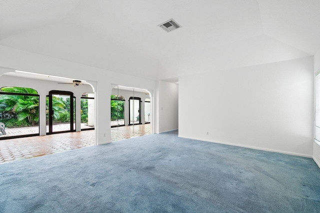 spare room featuring lofted ceiling, carpet, and ceiling fan