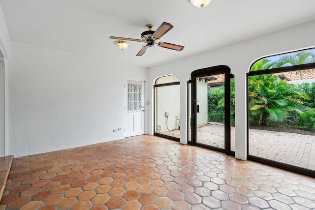 unfurnished room featuring ceiling fan and a wealth of natural light