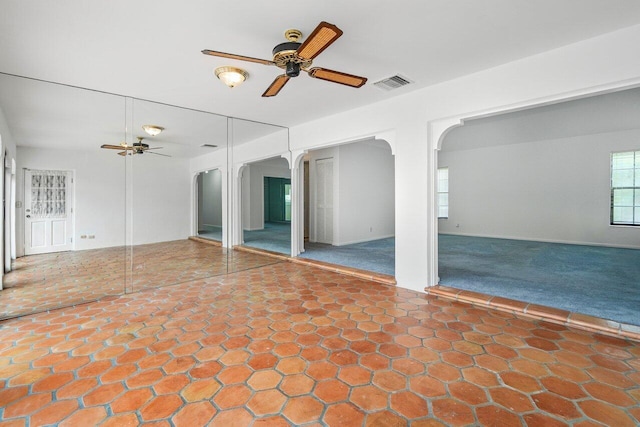 interior space with ceiling fan