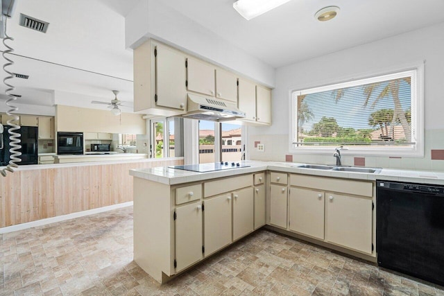 kitchen with a healthy amount of sunlight, black appliances, sink, cream cabinetry, and kitchen peninsula