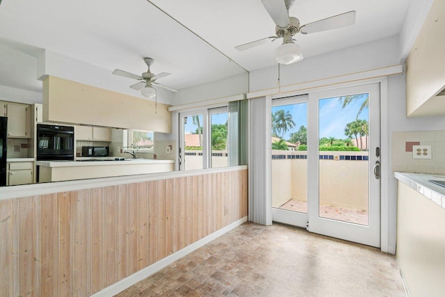 kitchen with ceiling fan, black appliances, and decorative backsplash