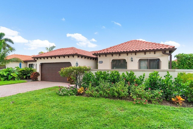 mediterranean / spanish home with a front yard and a garage