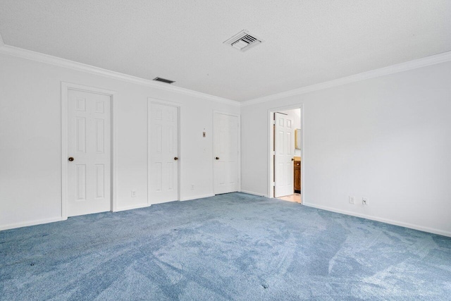 unfurnished bedroom with carpet, ornamental molding, and two closets