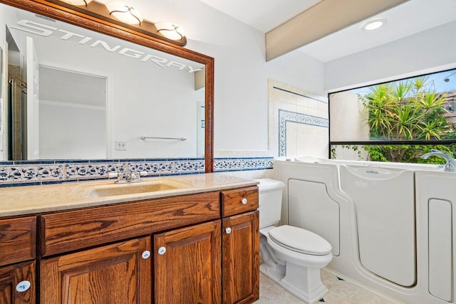 bathroom featuring vanity, toilet, tile patterned floors, and a washtub