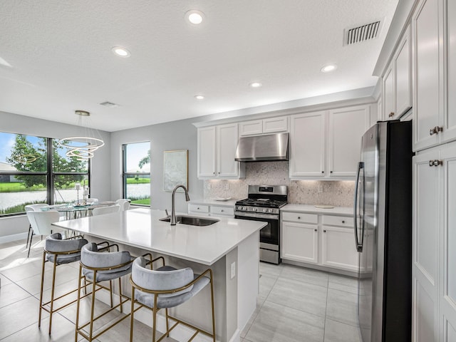 kitchen with stainless steel appliances, sink, decorative light fixtures, and a kitchen breakfast bar