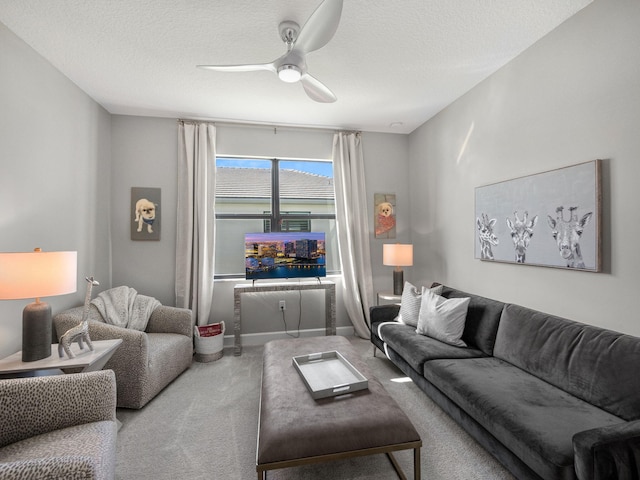 living room with a textured ceiling, carpet floors, and ceiling fan