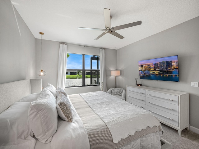 bedroom featuring a textured ceiling, carpet floors, and ceiling fan