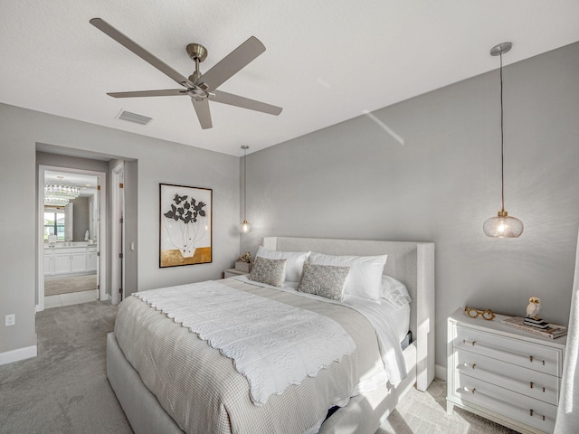 bedroom with ceiling fan, carpet floors, and ensuite bath