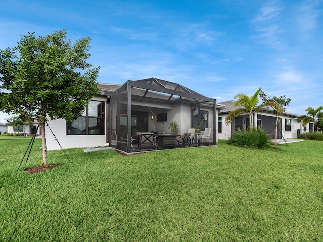 rear view of property with a patio area, glass enclosure, and a lawn