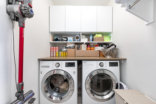 washroom with cabinets and washer and dryer