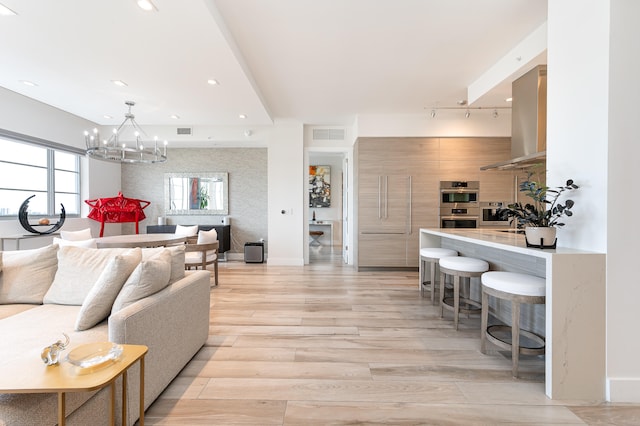 living room with a chandelier and light hardwood / wood-style flooring