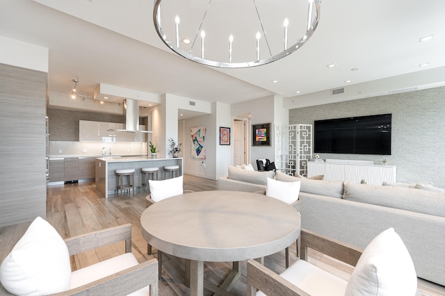 dining room with light wood-type flooring and a chandelier