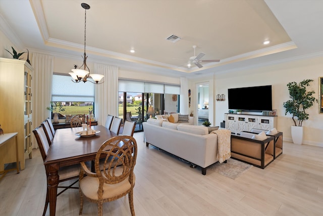 living room featuring light hardwood / wood-style floors, a raised ceiling, and ceiling fan with notable chandelier