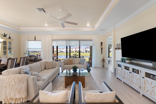 living room featuring light hardwood / wood-style floors, crown molding, a healthy amount of sunlight, and ceiling fan