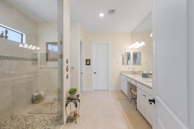 bathroom featuring vanity, a chandelier, a tile shower, and tile patterned flooring