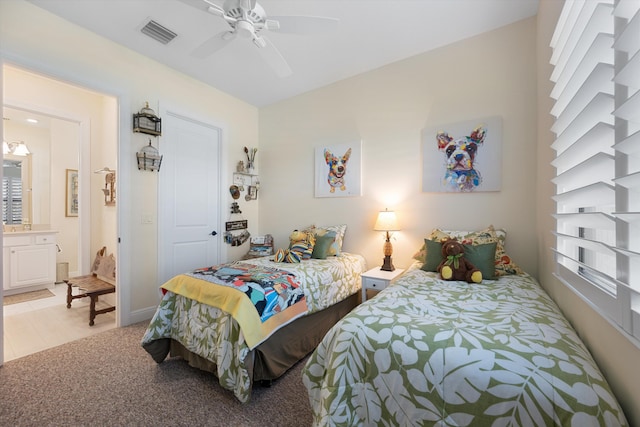 bedroom featuring ensuite bath, light colored carpet, and ceiling fan